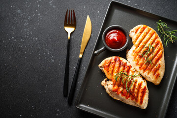 Canvas Print - Grilled meat. Chicken steak on black background. Top view with copy space.