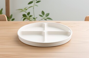 A minimalistic white plate with four sections, perfect for serving snacks or appetizers on a modern dining table.