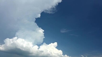 Wall Mural - time lapse of bright white summer clouds billowing and growing in a clean blue sky.