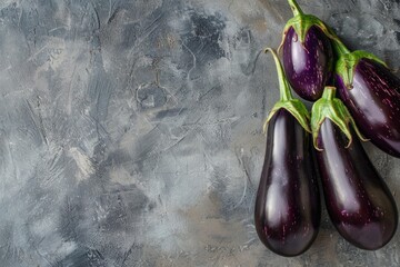 Poster - Bunch of ripe aubergines lying on a dark rustic backdrop with ample copy space