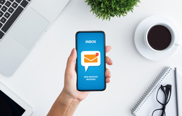 Poster - Email marketing and newsletter concept. Top view of unrecognizable young woman holding modern mobile phone with new mail notification on screen, creative collage