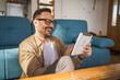 © Miljan Živković - One Man caucasian Holding Digital Tablet work at home Happy Smile