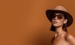 © Olga - Elegant tanned woman face portrait in brown color, beauty fashion model photo with glossy lips in hat and black sunglasses. Vertical template with copy space for web design or magazine article.