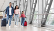 © Prostock-studio - Travel Advertisement. Portrait Of Happy Arab Family Walking With Luggage At Airport, Beautiful Middle Eastern Mother, Father And Little Daughter Going To Boarding, Enjoying Traveling Together