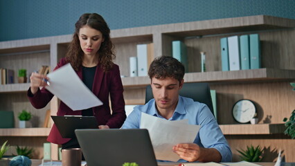 Wall Mural - Confident ceo examining documents talking with woman assistant in office closeup