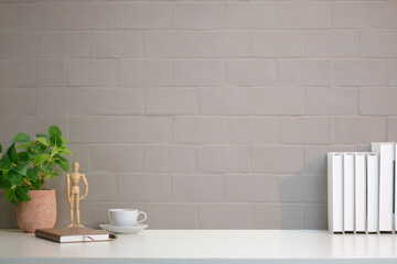 Wall Mural - A simple and modern workspace setup featuring a clean white desk against a light gray brick wall background.