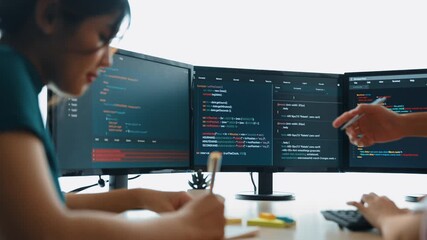 Slow motion back end software developer engineer for computer programming working together on debugging writing computing code, solving complex algorithms display on monitor in office. Burgeoning