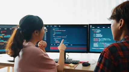 Slow motion back end software developer engineer for computer programming working together on debugging writing computing code, solving complex algorithms display on monitor in office. Burgeoning