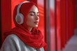 © Henrry L - A woman wearing a red scarf and headphones is sitting on a wall