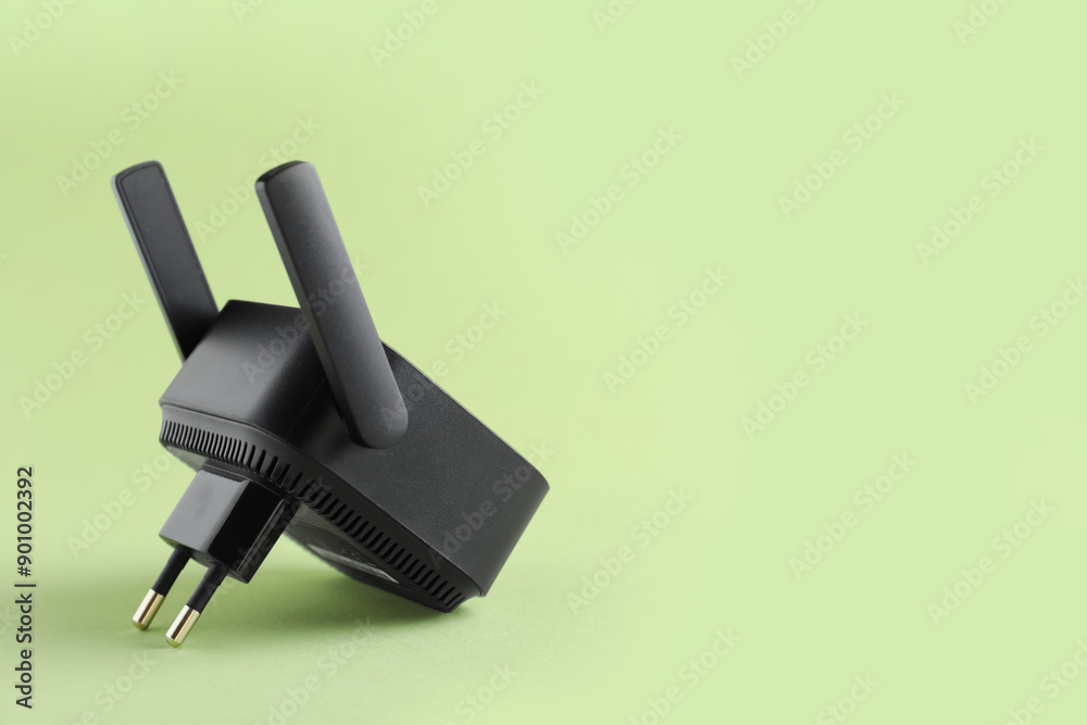 Black WiFi repeater on green background