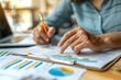 © momostudio - Close-up of a Hand Pointing at a Business Graph