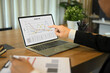 © Prathankarnpap - Senior businessman investor sitting at desk and reviewing a financial report on laptop screen