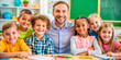 © Phlegmatic Tigress - Happy group of  kids and teacher at school in a light classroom