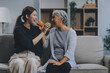 © ARMMY PICCA - Happy asian woman daughter hugging senior mother in the kitchen room eating healthy food happy enjoying.