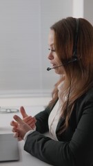 Poster - A confident businesswoman leads a virtual meeting at her office, showcasing focus. She wears a headset, essential for her communication with clients and colleagues. Her leadership shines through