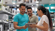 © PRASANNAPIX - young man and woman standing inside of appliances store