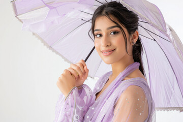 Wall Mural - young indian woman holding umbrella on white background