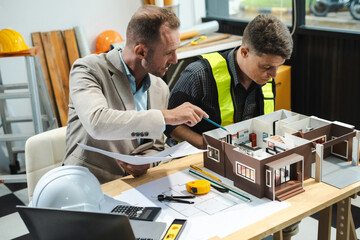 Wall Mural - Architecture and teamwork concept. Male engineers or business partners on a construction site, discussing project details.