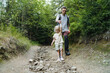 © Westend61 - Father and daughter walking on footpath in forest
