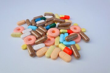 Various kinds of Pills capsules, tablets and caplets in close view on white background.