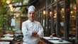 © paulmalaianu - Adult man chef de cuisine, standing in front of her restaurant.