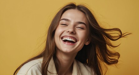 Wall Mural - teen laughing girl on plain yellow background model portrait lifestyle hair skin care ad concept copy space