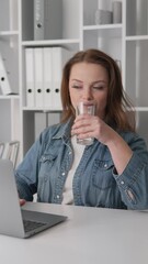 Poster - In a contemporary office, a dedicated professional woman is focused on her work, typing on her laptop and enjoying a drink. Her efficiency and commitment contribute to productivity and success