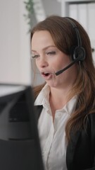 Poster - In an office setting, a focused businesswoman, a professional customer service representative, is diligently assisting and supporting clients while working at a computer, wearing a headset