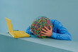 © VISTA by Westend61 - Frustrated businessman with mask of chaotic thoughts against blue background