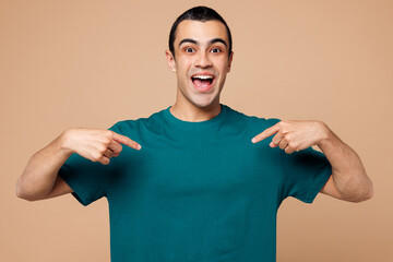 Wall Mural - Young shocked excited middle eastern man wear blue t-shirt casual clothes point index finger on himself look camera isolated on plain pastel light beige background studio portrait. Lifestyle concept.