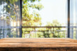 © oksa_studio - Empty wooden table top with blurred green garden open door background for product display