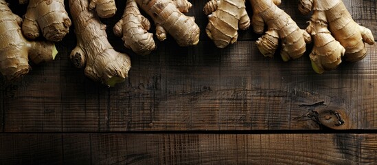 Poster - Ginger roots on a dark wooden backdrop with copy space image