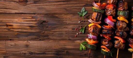Poster - Top view image of grilled meat skewers with vegetables on a wooden background providing copy space for text or design elements