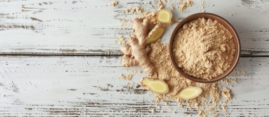 Aufkleber - Top view of a small bowl with ground ginger and a ginger root on a white wooden backdrop with room for text or image. copy space available