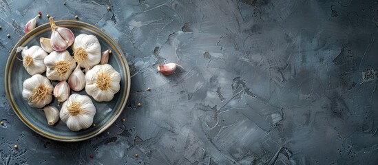Aufkleber - Copy space image of fresh garlic bulbs and cloves displayed on a plate against a blue grey stone background shot from above with selective focus and shallow depth of field