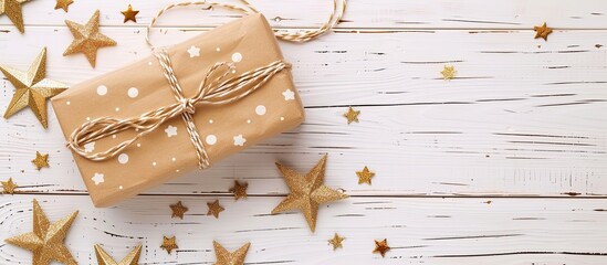 Poster - Gift box with star shaped decorations on a white wooden table background with ample copy space image