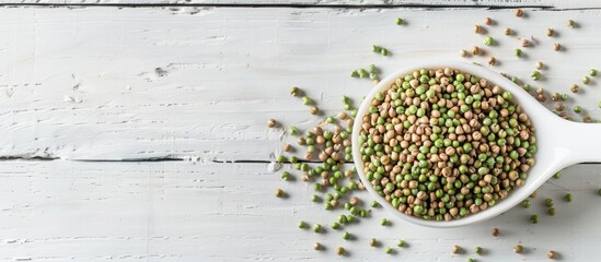 Poster - Top down view of raw green buckwheat grains in a spoon on a white wooden surface with room for text Additional copy space image available