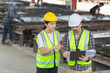 © JU.STOCKER - Engineer and female foreman worker with blueprints checking project at the precast concrete factory site, Engineer team in hardhats discussing on construction site