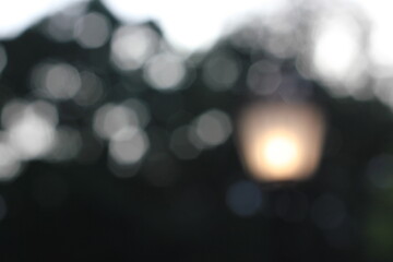 A blurry dreamy view of a street lantern glowing in the darkness.