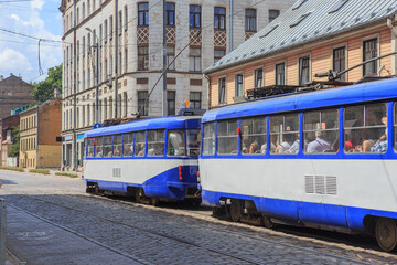 Wall Mural - old tram with passengers moves along the street