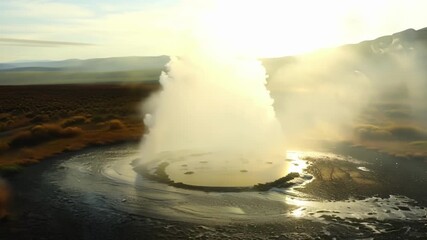 Sticker - A serene landscape as the first rays of sunlight hit a geyser creating a stunning display of steam and water.