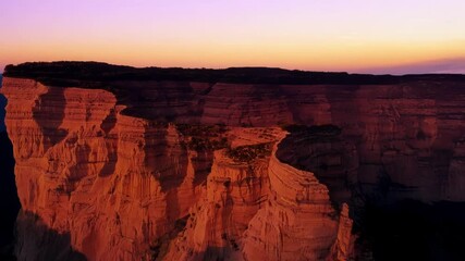 Poster - The golden hour paints the cliffs in a warm golden light before they fade into the blue of twilight.