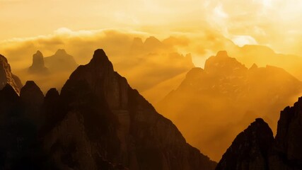 Poster - A majestic landscape of towering rocky peaks infused with the soft golden light of dusk.