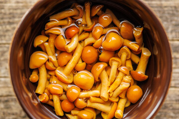 Wall Mural - Pickled nameko mushrooms.Traditional japanese mushrooms in bowl on wooden table. Top view.