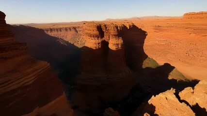 Poster - Zooming past cliff faces casting long shadows over the desert floor.