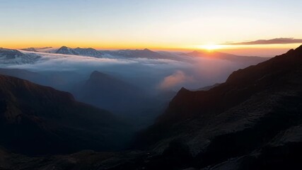 Poster - The dramatic contrast between the dark valleys and the glowing mountain tops creates a stunning composition at sunrise.