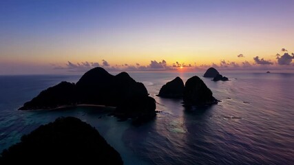 Poster - Witnessing the transition from day to night as the islands bask in the fading warmth of the sun before being enveloped by the dark blue of twilight.