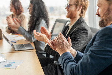 Aufkleber - A group of business professionals are seated around a conference table, clapping their hands in appreciation. A laptop and papers are visible on the table.