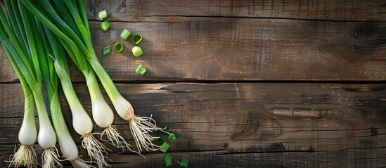 Wall Mural - Food presentation of fresh spring onions on a wooden table with copy space image.