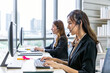 © wirojsid - Focused Asian female woman call center agents providing customer service in modern office environment.